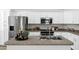 Modern kitchen with stainless steel appliances, white cabinetry, and center island with sink at 1120 S Valley Dr, Apache Junction, AZ 85120