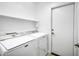 Functional laundry room equipped with a washer, dryer, and shelving for storage at 1120 S Valley Dr, Apache Junction, AZ 85120