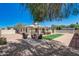 A large backyard with new patio cover and seating, BBQ, dining set, grassy area and gravel landscaping at 1701 W Clarendon Ave, Phoenix, AZ 85015