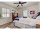 Bright bedroom featuring a ceiling fan, new wood-look flooring, white walls, and updated window shutters at 1701 W Clarendon Ave, Phoenix, AZ 85015