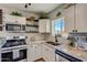 Updated kitchen features granite counters, stainless appliances, and decorative shelving at 1701 W Clarendon Ave, Phoenix, AZ 85015