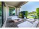 Cozy covered patio with comfortable seating, offering views of the lush backyard and pool at 17690 E Bronco Dr, Queen Creek, AZ 85142