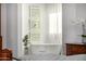 Bright bathroom with a soaking tub, decorative wall art, sheer curtains, and neutral tones at 17690 E Bronco Dr, Queen Creek, AZ 85142