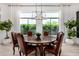 Bright dining room with large window, wood table, leather chairs, and elegant chandelier at 17690 E Bronco Dr, Queen Creek, AZ 85142