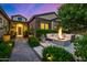 Cozy outdoor seating area featuring a modern fire pit, lush greenery, and ambient lighting at 17690 E Bronco Dr, Queen Creek, AZ 85142