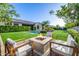 Charming backyard featuring a fire pit area with comfortable seating, a pool, and lush landscaping at 17690 E Bronco Dr, Queen Creek, AZ 85142