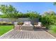 Cozy fire pit area with outdoor seating, complemented by lush greenery and a paver patio at 17690 E Bronco Dr, Queen Creek, AZ 85142