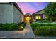 Inviting single-story home entrance with meticulously maintained landscaping and illuminated pathway at 17690 E Bronco Dr, Queen Creek, AZ 85142