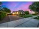 Beautiful home exterior featuring a three-car garage, manicured lawn and mature trees at 17690 E Bronco Dr, Queen Creek, AZ 85142