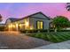 Exterior shot of house with three car garage, manicured lawn and sidewalk in front at 17690 E Bronco Dr, Queen Creek, AZ 85142