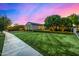 Well-manicured front lawn and garden of a charming home, illuminated against a twilight sky at 17690 E Bronco Dr, Queen Creek, AZ 85142