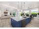 Open kitchen featuring large island with seating, stainless steel appliances, white cabinets, and modern lighting fixtures at 17690 E Bronco Dr, Queen Creek, AZ 85142