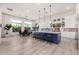 Spacious kitchen with an island, pendant lighting, white cabinets, and stainless steel appliances, adjacent to dining area at 17690 E Bronco Dr, Queen Creek, AZ 85142