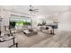 Bright, open-concept living room featuring neutral decor, large windows, and access to the kitchen and outdoor space at 17690 E Bronco Dr, Queen Creek, AZ 85142