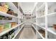 Spacious walk-in pantry featuring white shelving with recessed lighting and lovely tile floors at 17690 E Bronco Dr, Queen Creek, AZ 85142