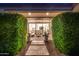 The covered patio leads to an open concept living space and is framed by symmetrical, neatly trimmed hedges at 17690 E Bronco Dr, Queen Creek, AZ 85142