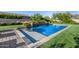 Lush backyard featuring a pristine pool with a water feature, complemented by well-maintained landscaping and stonework at 17690 E Bronco Dr, Queen Creek, AZ 85142