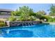 Sparkling pool with a stone waterfall feature and vibrant landscaping, creating a serene backyard oasis at 17690 E Bronco Dr, Queen Creek, AZ 85142