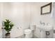 Half bathroom features a pedestal sink, decorative mirror, and neutral color palette at 17690 E Bronco Dr, Queen Creek, AZ 85142
