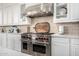 Close-up of a professional-grade stainless steel Wolf range with red knobs in a modern, well-equipped kitchen at 17690 E Bronco Dr, Queen Creek, AZ 85142