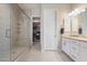 Bright bathroom featuring a glass-enclosed shower, walk-in closet, and double sink vanity at 18225 N 66Th Way, Phoenix, AZ 85054