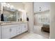 Well-lit bathroom featuring a double vanity, large mirror, and views into the bedroom at 18225 N 66Th Way, Phoenix, AZ 85054