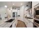 Island kitchen with stainless steel appliances, gas range, stone countertops, and wood-look tile flooring at 18225 N 66Th Way, Phoenix, AZ 85054