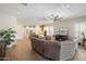 Open-concept living room featuring wood-look tile floors, a ceiling fan, and a comfortable sectional sofa at 18225 N 66Th Way, Phoenix, AZ 85054