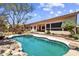 Backyard oasis featuring a sparkling pool, mature trees, and comfortable seating area at 1943 E Drake Dr, Tempe, AZ 85283