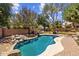 Backyard pool featuring mature trees, a stone waterfall, and an outdoor dining set for entertaining at 1943 E Drake Dr, Tempe, AZ 85283