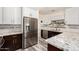 Modern kitchen featuring white cabinets, stainless steel appliances, and elegant granite countertops with a mosaic backsplash at 23119 W Papago St, Buckeye, AZ 85326