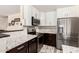Well-lit kitchen boasts white cabinets, stainless steel appliances, granite countertops, and a chic mosaic tile backsplash at 23119 W Papago St, Buckeye, AZ 85326