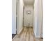 Hallway with wood flooring, a decorative mirror, and white walls provides a seamless transition between rooms at 2358 E Peach Tree Dr, Chandler, AZ 85249