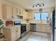 Modern kitchen with stainless steel appliances, white cabinets, and countertops, accented by neutral backsplash and flooring at 2358 E Peach Tree Dr, Chandler, AZ 85249