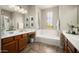 Bright bathroom with double sinks, soaking tub, and decorative lighting at 2418 W Jake Hvn, Phoenix, AZ 85085