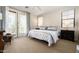 Bright main bedroom featuring balcony access, a ceiling fan, and neutral carpeting at 2418 W Jake Hvn, Phoenix, AZ 85085