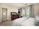 Bright main bedroom featuring balcony access, neutral carpeting, and a door to the bathroom at 2418 W Jake Hvn, Phoenix, AZ 85085