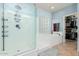 Modern bathroom with a glass-enclosed shower, soaking tub, and a walk-in closet at 26529 N 167Th Ave, Surprise, AZ 85387