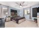 Bedroom with a ceiling fan, carpet flooring, and blue walls complemented by neutral curtains and window blinds at 26529 N 167Th Ave, Surprise, AZ 85387