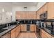 Modern kitchen boasts stainless steel appliances, wood cabinets, and sleek black countertops at 2989 N 44Th St # 3044, Phoenix, AZ 85018