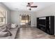 Cozy living room with a ceiling fan, sliding glass door, and entertainment center at 3020 E Megan St, Gilbert, AZ 85295