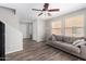 Cozy living room featuring a ceiling fan, large windows, and comfortable sofa at 3020 E Megan St, Gilbert, AZ 85295