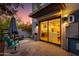 Inviting outdoor patio with a seating area, lush greenery, and a view of the kitchen through sliding glass doors at 340 E Osborn Rd # 1, Phoenix, AZ 85012