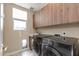 Functional laundry room featuring high-end washer and dryer, marble floors, and plenty of cabinet storage at 340 E Osborn Rd # 1, Phoenix, AZ 85012