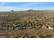 A scenic aerial view of a suburban community nestled amidst the natural desert landscape with mountain views at 3551 W Hidden Mountain Ln, Anthem, AZ 85086