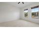 A bright bedroom featuring a ceiling fan, tile flooring, and two windows with wood blinds at 3551 W Hidden Mountain Ln, Anthem, AZ 85086
