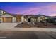 Charming single-story home with desert landscaping, three-car garage, and a tile roof at dusk at 3551 W Hidden Mountain Ln, Anthem, AZ 85086