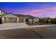 Charming single-story home with desert landscaping, three-car garage, and a tile roof at dusk at 3551 W Hidden Mountain Ln, Anthem, AZ 85086