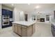 Open kitchen with large island and stainless appliances next to a cozy living room and fireplace at 3551 W Hidden Mountain Ln, Anthem, AZ 85086