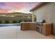 View of a built-in outdoor kitchen area next to a sparkling pool, ideal for outdoor dining at 3551 W Hidden Mountain Ln, Anthem, AZ 85086